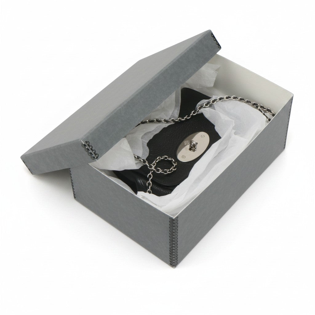 Kept Store acid-free grey storage box protecting a small black leather crossbody handbag with tissue paper.