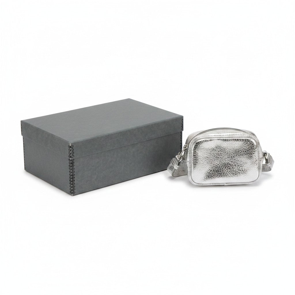 Kept Store acid-free grey storage box protecting a small metallic silver crossbody handbag on a white background.